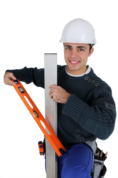 Worker with level spirit on white background — Stock Photo, Image