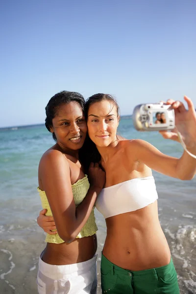 Två kvinnliga vänner att ta självporträtt på stranden — Stockfoto