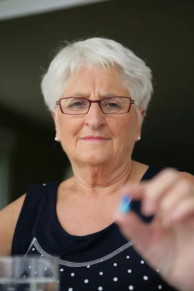 Senior woman taking pills — Stock Photo, Image