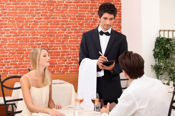 Couple being served by a waiter Stock Image