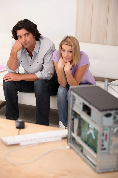 Paar zat aan de voorzijde van gebroken computer — Stockfoto