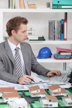 Young architect sitting at his desk clipart