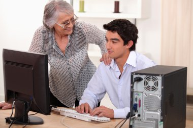 Man helping elderly woman with computer problems clipart