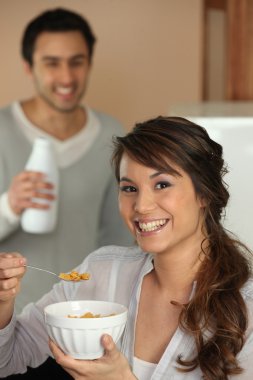 Woman eating cereal for breakfast clipart