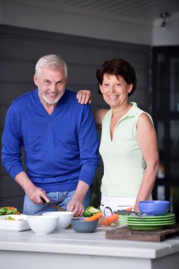 Elderly couple preparing a meal clipart