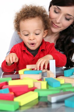 Woman with child and blocks clipart