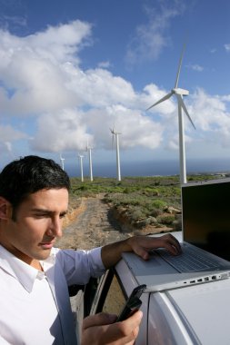 Man stood by wind farm taking readings clipart