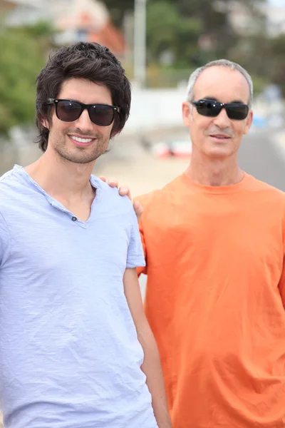Far och vuxen son bär nyanser — Stockfoto