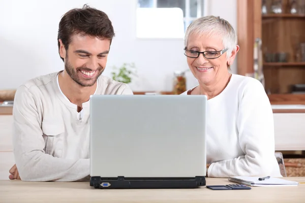 Giovane uomo e sua madre utilizzando il computer portatile — Foto Stock