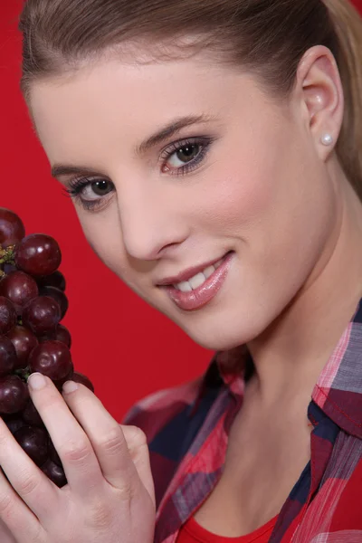 Jovem mulher segurando uvas — Fotografia de Stock