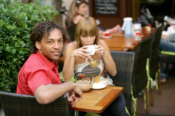 Pareja tomando una copa en la terraza de un café — Foto de Stock