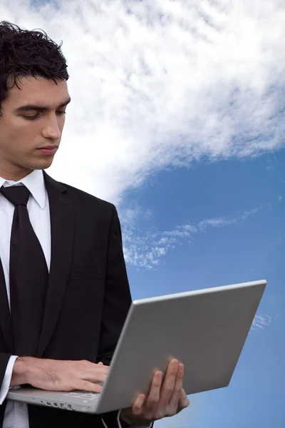 Mladý obchodní muž dělá počítač mimo — Stock fotografie