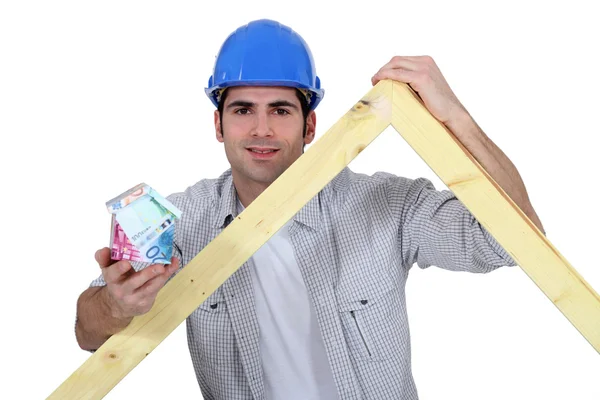 Carpenter stood with wooden truss and money — Stock Photo, Image