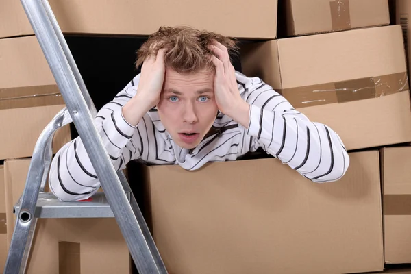 Man surrounded by stacks of cardboards — Stock Photo, Image