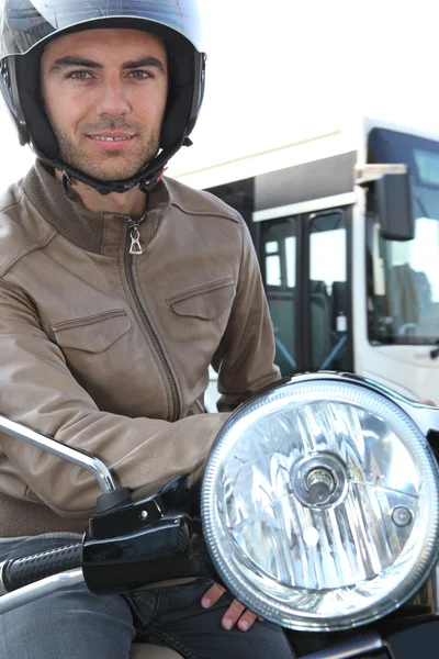 Άνθρωπος σε ένα μοτοποδήλατο με ένα λεωφορείο στο παρασκήνιο — Φωτογραφία Αρχείου