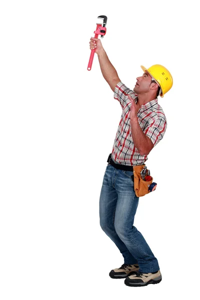 Tradesman usando uma chave de tubo para apertar um objeto — Fotografia de Stock