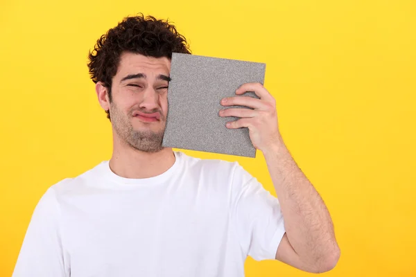 Homem pressionando azulejo contra rosto — Fotografia de Stock