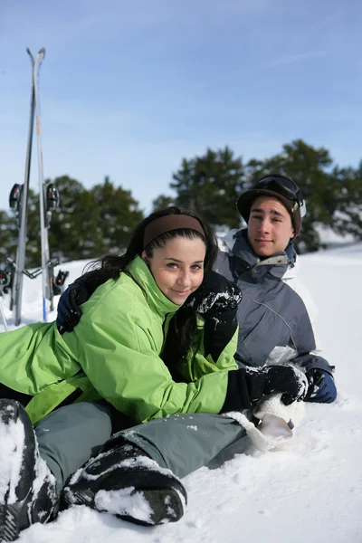 Jovem casal sentou-se na neve — Fotografia de Stock