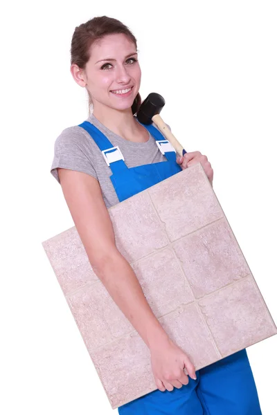 Woman with a floor tile and a mallet — Stock Photo, Image