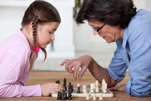 Νεαρό κορίτσι που παίζει σκάκι με τη γιαγιά — Φωτογραφία Αρχείου
