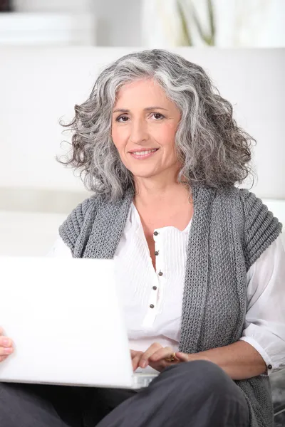 Μέσης ηλικίας γυναίκα με φορητό υπολογιστή — Φωτογραφία Αρχείου