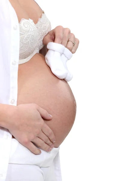 Zwanger vrouw met baby schoenen — Stockfoto