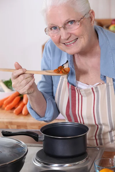 An old lady cooking. — Stockfoto