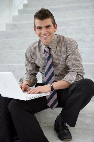 Ung chef med en bärbar dator på ett trapphus — Stockfoto