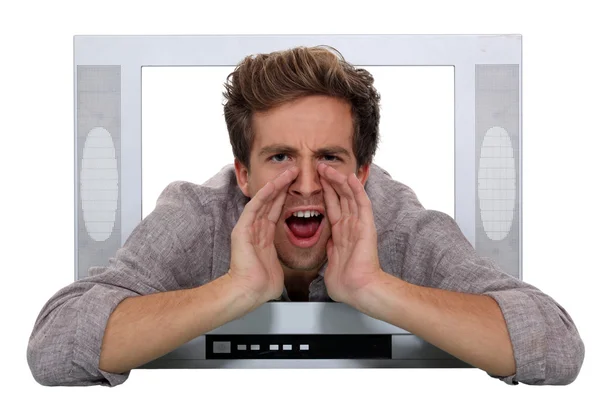 Un uomo che urla attraverso una TV . — Foto Stock