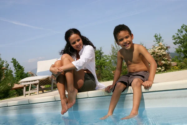 Mor och son doppa fötterna i poolen — Stockfoto