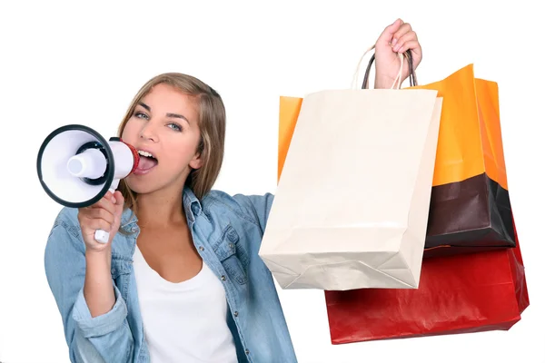 Kobieta trzyma torby na zakupy i krzyczy do głośnika — Zdjęcie stockowe