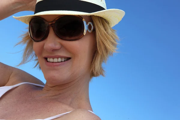 Femme portant des lunettes de soleil et un chapeau de paille — Photo