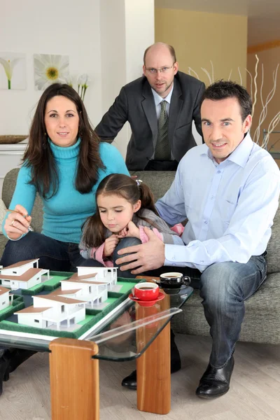 Architekt mit Familie schaut sich ein Baumodell an — Stockfoto