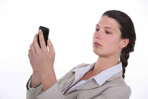 Businesswoman looking at her mobile phone Stock Image