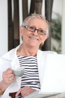 Old lady with laptop and coffee clipart