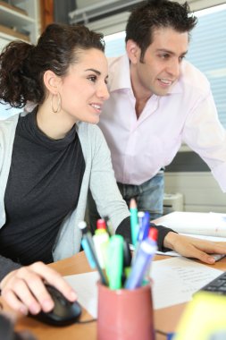 Coworkers looking at a computer screen clipart