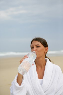 Woman drinking a bottle of water clipart