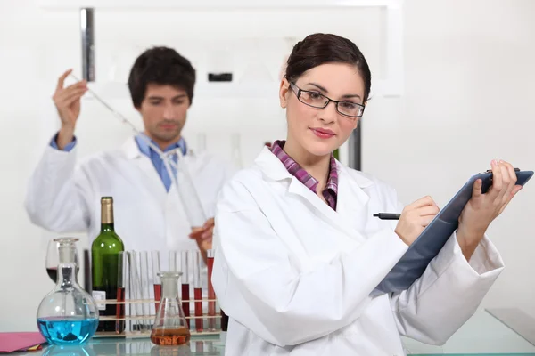 Работники лаборатории тестируют вино — стоковое фото