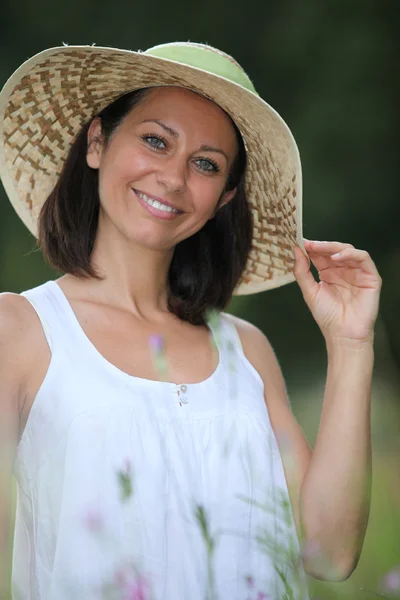 Morena atraente em um chapéu de palha de verão — Fotografia de Stock