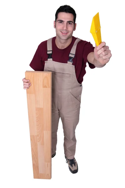 Carpintero posando con tarimas y un flotador — Foto de Stock