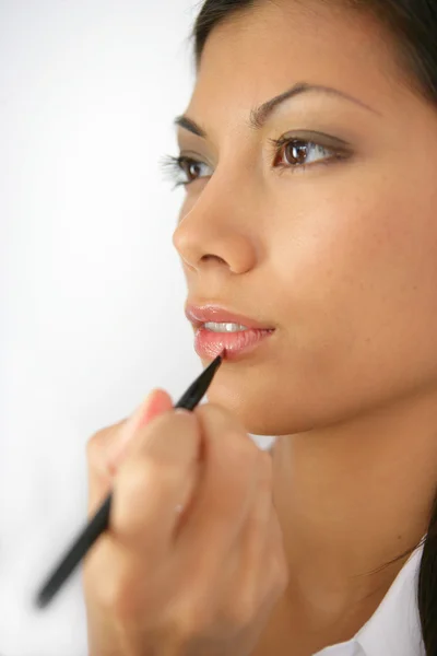 Mulher usando lápis de maquiagem — Fotografia de Stock