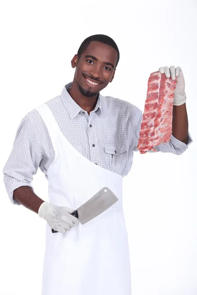 Glad slaktare visar kött — Stockfoto