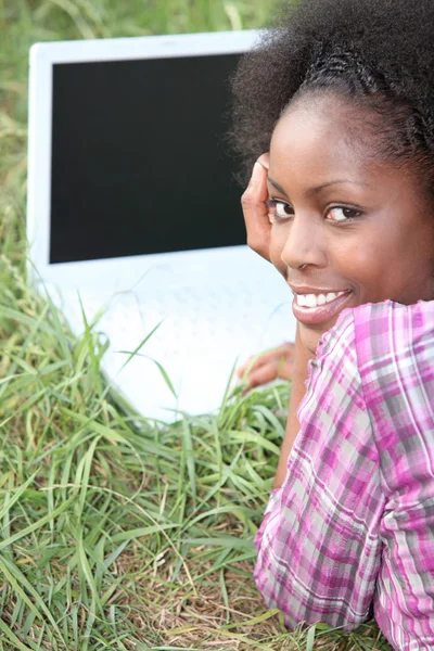 stock image Young woman with a blank screened laptop in the grass