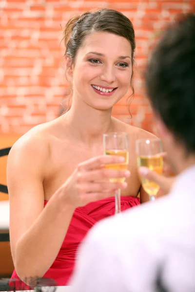 Пара в ресторане с флейтами для шампанского — стоковое фото