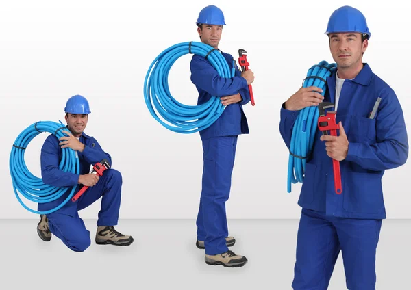 Blauwe kraag met harde hoed slang te voeren op zijn schouder — Stockfoto