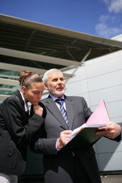 Les hommes d'affaires examinant la paperasserie à l'extérieur — Photo