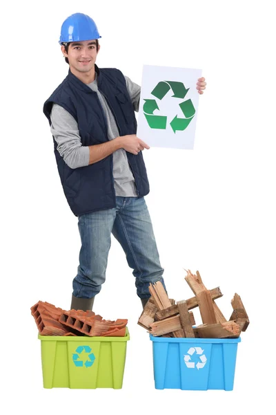 Jovem pedreiro segurando logotipo reciclagem — Fotografia de Stock