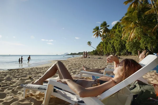 Vrouw zonnebaden op het strand — Stockfoto