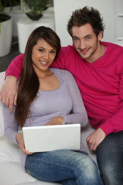 Atraktivní pár seděl s přenosným počítačem — Stock fotografie