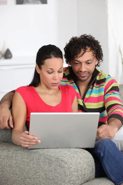 Пара вдома дивиться на ноутбук — стокове фото